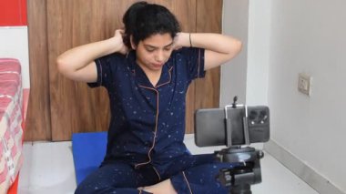 Evde yoga yapan genç Hintli bir kadın çevrimiçi yoga seansında güzel bir kız temel yoga pozisyonunda Asyalı bir kadın kapalı alanda yoga yapıyor. 