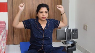 Evde yoga yapan genç Hintli bir kadın çevrimiçi yoga seansında güzel bir kız temel yoga pozisyonunda Asyalı bir kadın kapalı alanda yoga yapıyor. 