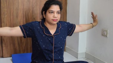 Evde yoga yapan genç Hintli bir kadın çevrimiçi yoga seansında güzel bir kız temel yoga pozisyonunda Asyalı bir kadın kapalı alanda yoga yapıyor. 