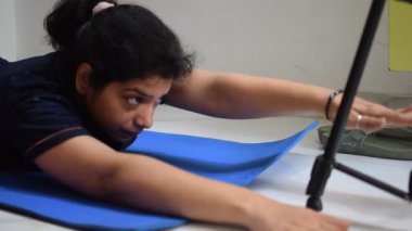 Evde yoga yapan genç Hintli bir kadın çevrimiçi yoga seansında güzel bir kız temel yoga pozisyonunda Asyalı bir kadın kapalı alanda yoga yapıyor. 