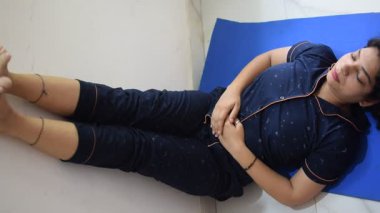 Evde yoga yapan genç Hintli bir kadın çevrimiçi yoga seansında güzel bir kız temel yoga pozisyonunda Asyalı bir kadın kapalı alanda yoga yapıyor. 