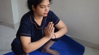 Evde yoga yapan genç Hintli bir kadın çevrimiçi yoga seansında güzel bir kız temel yoga pozisyonunda Asyalı bir kadın kapalı alanda yoga yapıyor. 