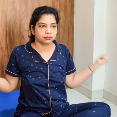Evde yoga yapan genç Hintli bir kadın çevrimiçi yoga seansında güzel bir kız temel yoga pozisyonunda Asyalı bir kadın kapalı alanda yoga yapıyor.