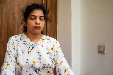 Evde yoga yapan genç Hintli bir kadın çevrimiçi yoga seansında güzel bir kız temel yoga pozisyonunda Asyalı bir kadın kapalı alanda yoga yapıyor.