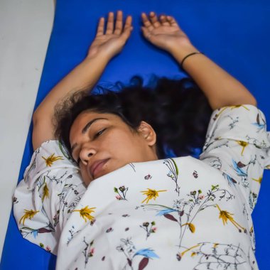 Evde yoga yapan genç Hintli bir kadın çevrimiçi yoga seansında güzel bir kız temel yoga pozisyonunda Asyalı bir kadın kapalı alanda yoga yapıyor.