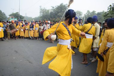 Delhi, Hindistan, 17 Kasım 2024 - Doğu Delhi bölgesinde Guru Nanak Dev, Nagar Kirtan 'ın doğum günü dolayısıyla geleneksel Nagar Kirtan, geleneksel Nagar geçit töreninde Sihler gatka ve dövüş sanatlarını sergiliyor