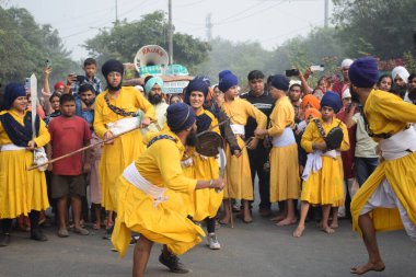 Delhi, Hindistan, 17 Kasım 2024 - Doğu Delhi bölgesinde Guru Nanak Dev, Nagar Kirtan 'ın doğum günü dolayısıyla geleneksel Nagar Kirtan, geleneksel Nagar geçit töreninde Sihler gatka ve dövüş sanatlarını sergiliyor