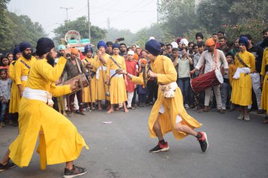 Delhi, Hindistan, 17 Kasım 2024 - Doğu Delhi bölgesinde Guru Nanak Dev, Nagar Kirtan 'ın doğum günü dolayısıyla geleneksel Nagar Kirtan, geleneksel Nagar geçit töreninde Sihler gatka ve dövüş sanatlarını sergiliyor