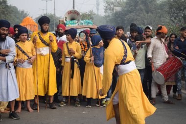 Delhi, Hindistan, 17 Kasım 2024 - Doğu Delhi bölgesinde Guru Nanak Dev, Nagar Kirtan 'ın doğum günü dolayısıyla geleneksel Nagar Kirtan, geleneksel Nagar geçit töreninde Sihler gatka ve dövüş sanatlarını sergiliyor