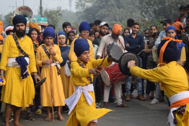 Delhi, Hindistan, 17 Kasım 2024 - Doğu Delhi bölgesinde Guru Nanak Dev, Nagar Kirtan 'ın doğum günü dolayısıyla geleneksel Nagar Kirtan, geleneksel Nagar geçit töreninde Sihler gatka ve dövüş sanatlarını sergiliyor