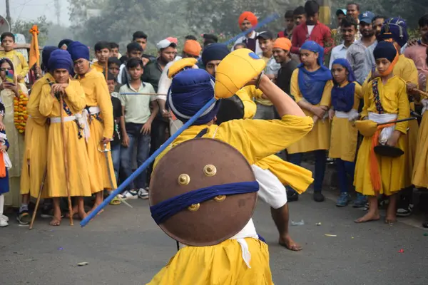 Delhi, Hindistan, 17 Kasım 2024 - Doğu Delhi bölgesinde Guru Nanak Dev, Nagar Kirtan 'ın doğum günü dolayısıyla geleneksel Nagar Kirtan, geleneksel Nagar geçit töreninde Sihler gatka ve dövüş sanatlarını sergiliyor