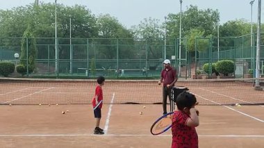 Delhi, Hindistan, 17 Şubat 2025 - Maha Open için kil tenis kortunda antrenörlük yapan genç tenisçiler, yaklaşan turnuva için küçük tenis oyuncuları antrenman yapıyor