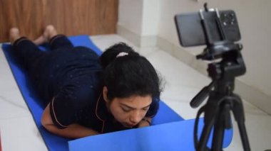 Evde yoga yapan genç Hintli bir kadın çevrimiçi yoga seansında güzel bir kız temel yoga pozisyonunda Asyalı bir kadın kapalı alanda yoga yapıyor. 