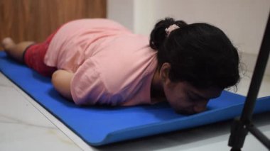 Evde yoga yapan genç Hintli bir kadın çevrimiçi yoga seansında güzel bir kız temel yoga pozisyonunda Asyalı bir kadın kapalı alanda yoga yapıyor. 