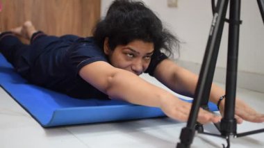 Evde yoga yapan genç Hintli bir kadın çevrimiçi yoga seansında güzel bir kız temel yoga pozisyonunda Asyalı bir kadın kapalı alanda yoga yapıyor. 