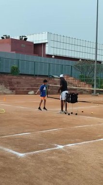 Delhi, Hindistan, 17 Şubat 2025 - Maha Open için kil tenis kortunda antrenörlük yapan genç tenisçiler, yaklaşan turnuva için küçük tenis oyuncuları antrenman yapıyor