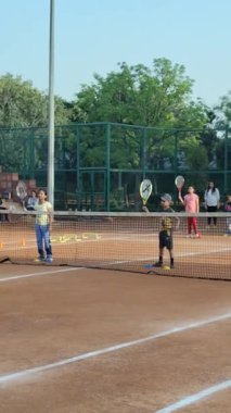 Delhi, Hindistan, 17 Şubat 2025 - Maha Open için kil tenis kortunda antrenörlük yapan genç tenisçiler, yaklaşan turnuva için küçük tenis oyuncuları antrenman yapıyor