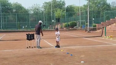 Delhi, Hindistan, 17 Şubat 2025 - Maha Open için kil tenis kortunda antrenörlük yapan genç tenisçiler, yaklaşan turnuva için küçük tenis oyuncuları antrenman yapıyor
