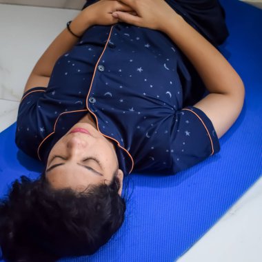 Evde yoga yapan genç Hintli bir kadın çevrimiçi yoga seansında güzel bir kız temel yoga pozisyonunda Asyalı bir kadın kapalı alanda yoga yapıyor.