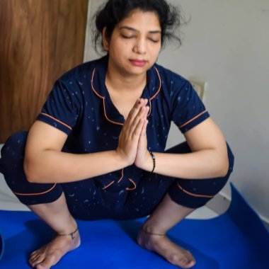 Evde yoga yapan genç Hintli bir kadın çevrimiçi yoga seansında güzel bir kız temel yoga pozisyonunda Asyalı bir kadın kapalı alanda yoga yapıyor.