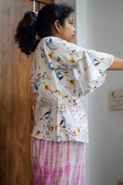 Evde yoga yapan genç Hintli bir kadın çevrimiçi yoga seansında güzel bir kız temel yoga pozisyonunda Asyalı bir kadın kapalı alanda yoga yapıyor.