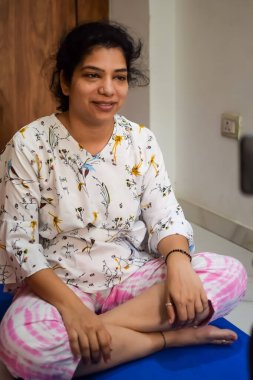 Evde yoga yapan genç Hintli bir kadın çevrimiçi yoga seansında güzel bir kız temel yoga pozisyonunda Asyalı bir kadın kapalı alanda yoga yapıyor.