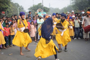 Delhi, Hindistan, 17 Kasım 2024 - Doğu Delhi bölgesinde Guru Nanak Dev, Nagar Kirtan 'ın doğum günü dolayısıyla geleneksel Nagar Kirtan, geleneksel Nagar geçit töreninde Sihler gatka ve dövüş sanatlarını sergiliyor