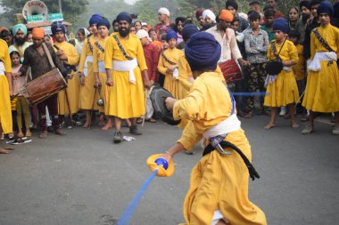 Delhi, Hindistan, 17 Kasım 2024 - Doğu Delhi bölgesinde Guru Nanak Dev, Nagar Kirtan 'ın doğum günü dolayısıyla geleneksel Nagar Kirtan, geleneksel Nagar geçit töreninde Sihler gatka ve dövüş sanatlarını sergiliyor