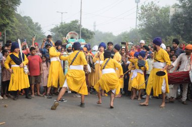 Delhi, Hindistan, 17 Kasım 2024 - Doğu Delhi bölgesinde Guru Nanak Dev, Nagar Kirtan 'ın doğum günü dolayısıyla geleneksel Nagar Kirtan, geleneksel Nagar geçit töreninde Sihler gatka ve dövüş sanatlarını sergiliyor
