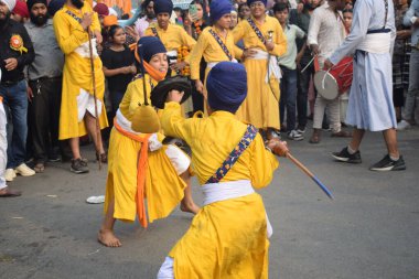 Delhi, Hindistan, 17 Kasım 2024 - Doğu Delhi bölgesinde Guru Nanak Dev, Nagar Kirtan 'ın doğum günü dolayısıyla geleneksel Nagar Kirtan, geleneksel Nagar geçit töreninde Sihler gatka ve dövüş sanatlarını sergiliyor