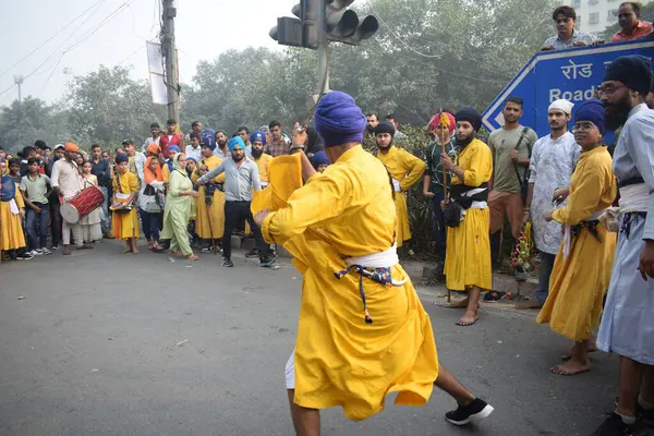 Delhi, Hindistan, 17 Kasım 2024 - Doğu Delhi bölgesinde Guru Nanak Dev, Nagar Kirtan 'ın doğum günü dolayısıyla geleneksel Nagar Kirtan, geleneksel Nagar geçit töreninde Sihler gatka ve dövüş sanatlarını sergiliyor