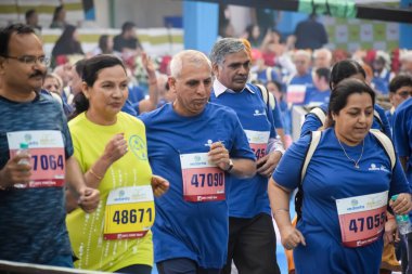 Yeni Delhi, Hindistan - 20 Ekim 2024 - Vedanta Delhi Yarı Maraton yarışına katılan yaşlılar maraton katılımcılarının bitiş çizgisini geçmek üzere oldukları Delhi Yarı Maratonu 2024