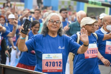 Yeni Delhi, Hindistan - 20 Ekim 2024 - Vedanta Delhi Yarı Maraton yarışına katılan yaşlılar maraton katılımcılarının bitiş çizgisini geçmek üzere oldukları Delhi Yarı Maratonu 2024