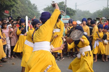 Delhi, Hindistan, 17 Kasım 2024 - Doğu Delhi bölgesinde Guru Nanak Dev, Nagar Kirtan 'ın doğum günü dolayısıyla geleneksel Nagar Kirtan, geleneksel Nagar geçit töreninde Sihler gatka ve dövüş sanatlarını sergiliyor