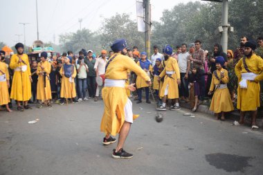 Delhi, Hindistan, 17 Kasım 2024 - Doğu Delhi bölgesinde Guru Nanak Dev, Nagar Kirtan 'ın doğum günü dolayısıyla geleneksel Nagar Kirtan, geleneksel Nagar geçit töreninde Sihler gatka ve dövüş sanatlarını sergiliyor