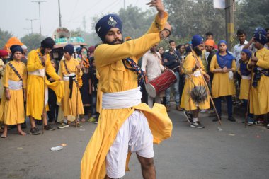 Delhi, Hindistan, 17 Kasım 2024 - Doğu Delhi bölgesinde Guru Nanak Dev, Nagar Kirtan 'ın doğum günü dolayısıyla geleneksel Nagar Kirtan, geleneksel Nagar geçit töreninde Sihler gatka ve dövüş sanatlarını sergiliyor