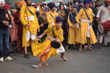 Delhi, Hindistan, 17 Kasım 2024 - Doğu Delhi bölgesinde Guru Nanak Dev, Nagar Kirtan 'ın doğum günü dolayısıyla geleneksel Nagar Kirtan, geleneksel Nagar geçit töreninde Sihler gatka ve dövüş sanatlarını sergiliyor