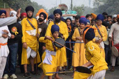 Delhi, Hindistan, 17 Kasım 2024 - Doğu Delhi bölgesinde Guru Nanak Dev, Nagar Kirtan 'ın doğum günü dolayısıyla geleneksel Nagar Kirtan, geleneksel Nagar geçit töreninde Sihler gatka ve dövüş sanatlarını sergiliyor