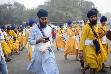 Delhi, Hindistan, 17 Kasım 2024 - Doğu Delhi bölgesinde Guru Nanak Dev, Nagar Kirtan 'ın doğum günü dolayısıyla geleneksel Nagar Kirtan, geleneksel Nagar geçit töreninde Sihler gatka ve dövüş sanatlarını sergiliyor