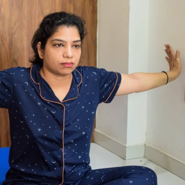 Evde yoga yapan genç Hintli bir kadın çevrimiçi yoga seansında güzel bir kız temel yoga pozisyonunda Asyalı bir kadın kapalı alanda yoga yapıyor.