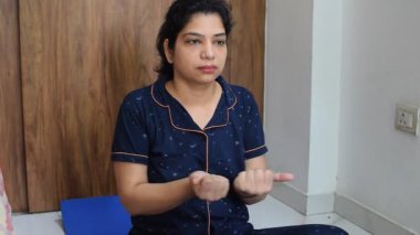 Evde yoga yapan genç Hintli bir kadın çevrimiçi yoga seansında güzel bir kız temel yoga pozisyonunda Asyalı bir kadın kapalı alanda yoga yapıyor. 