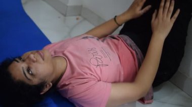 Evde yoga yapan genç Hintli bir kadın çevrimiçi yoga seansında güzel bir kız temel yoga pozisyonunda Asyalı bir kadın kapalı alanda yoga yapıyor. 