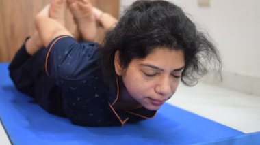 Evde yoga yapan genç Hintli bir kadın çevrimiçi yoga seansında güzel bir kız temel yoga pozisyonunda Asyalı bir kadın kapalı alanda yoga yapıyor. 