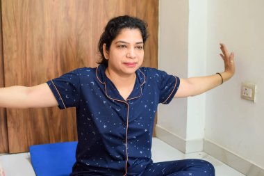 Evde yoga yapan genç Hintli bir kadın çevrimiçi yoga seansında güzel bir kız temel yoga pozisyonunda Asyalı bir kadın kapalı alanda yoga yapıyor.