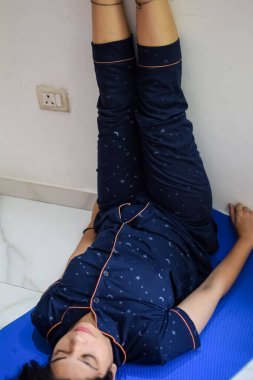 Evde yoga yapan genç Hintli bir kadın çevrimiçi yoga seansında güzel bir kız temel yoga pozisyonunda Asyalı bir kadın kapalı alanda yoga yapıyor.