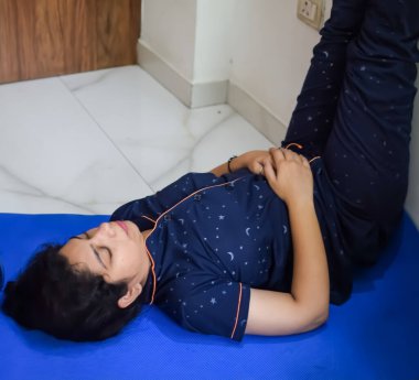 Evde yoga yapan genç Hintli bir kadın çevrimiçi yoga seansında güzel bir kız temel yoga pozisyonunda Asyalı bir kadın kapalı alanda yoga yapıyor.