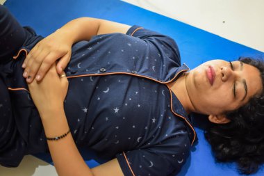 Evde yoga yapan genç Hintli bir kadın çevrimiçi yoga seansında güzel bir kız temel yoga pozisyonunda Asyalı bir kadın kapalı alanda yoga yapıyor.