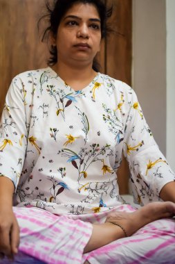 Evde yoga yapan genç Hintli bir kadın çevrimiçi yoga seansında güzel bir kız temel yoga pozisyonunda Asyalı bir kadın kapalı alanda yoga yapıyor.