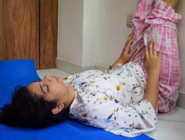 Evde yoga yapan genç Hintli bir kadın çevrimiçi yoga seansında güzel bir kız temel yoga pozisyonunda Asyalı bir kadın kapalı alanda yoga yapıyor.