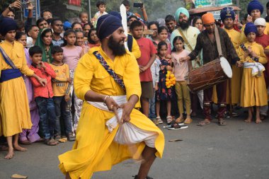 Delhi, Hindistan, 17 Kasım 2024 - Doğu Delhi bölgesinde Guru Nanak Dev, Nagar Kirtan 'ın doğum günü dolayısıyla geleneksel Nagar Kirtan, geleneksel Nagar geçit töreninde Sihler gatka ve dövüş sanatlarını sergiliyor